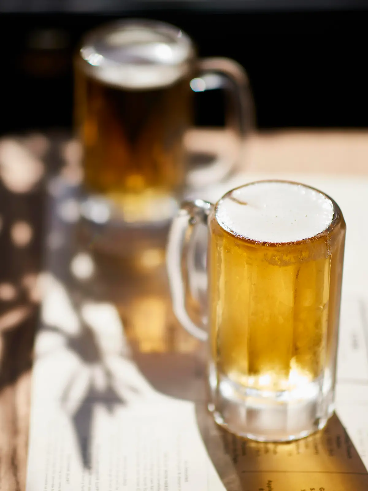Two glasses of beer in the sunshine on the table