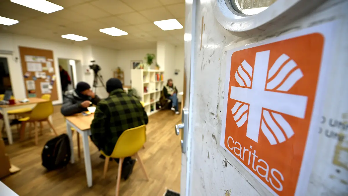 Der "Tagestreff CariCare", Aufenthaltsstätte für wohnungslose Menschen in der Hamburger Innenstadt, am 16. November 2022 in Hamburg. Auf der Eingangstür klebt das Flammenkreuz, Logo der Caritas.