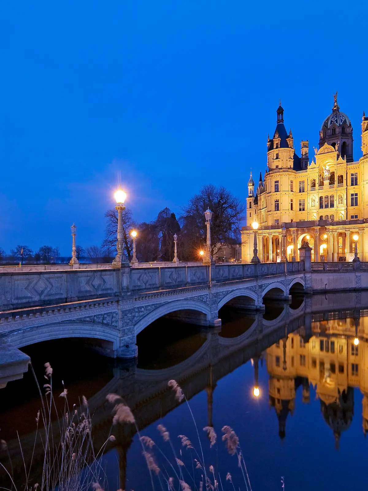 Beleuchtetes Schweriner Schloss mit der Schlossbrücke zur Schlossinsel am Abend, Schwerin, Mecklenburg-Vorpommern, Deutschland, Europa