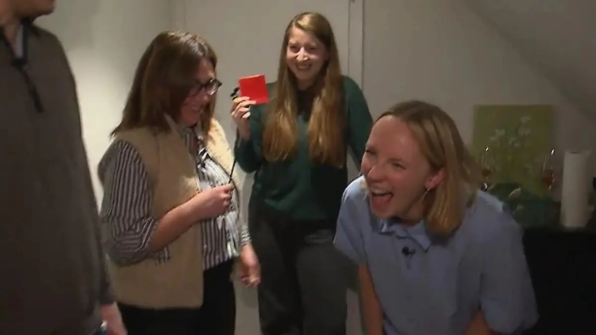 Das perfekte Dinner: Gastgeberin Radost lachend in ihrem Flur inmitten ihrer Gäste