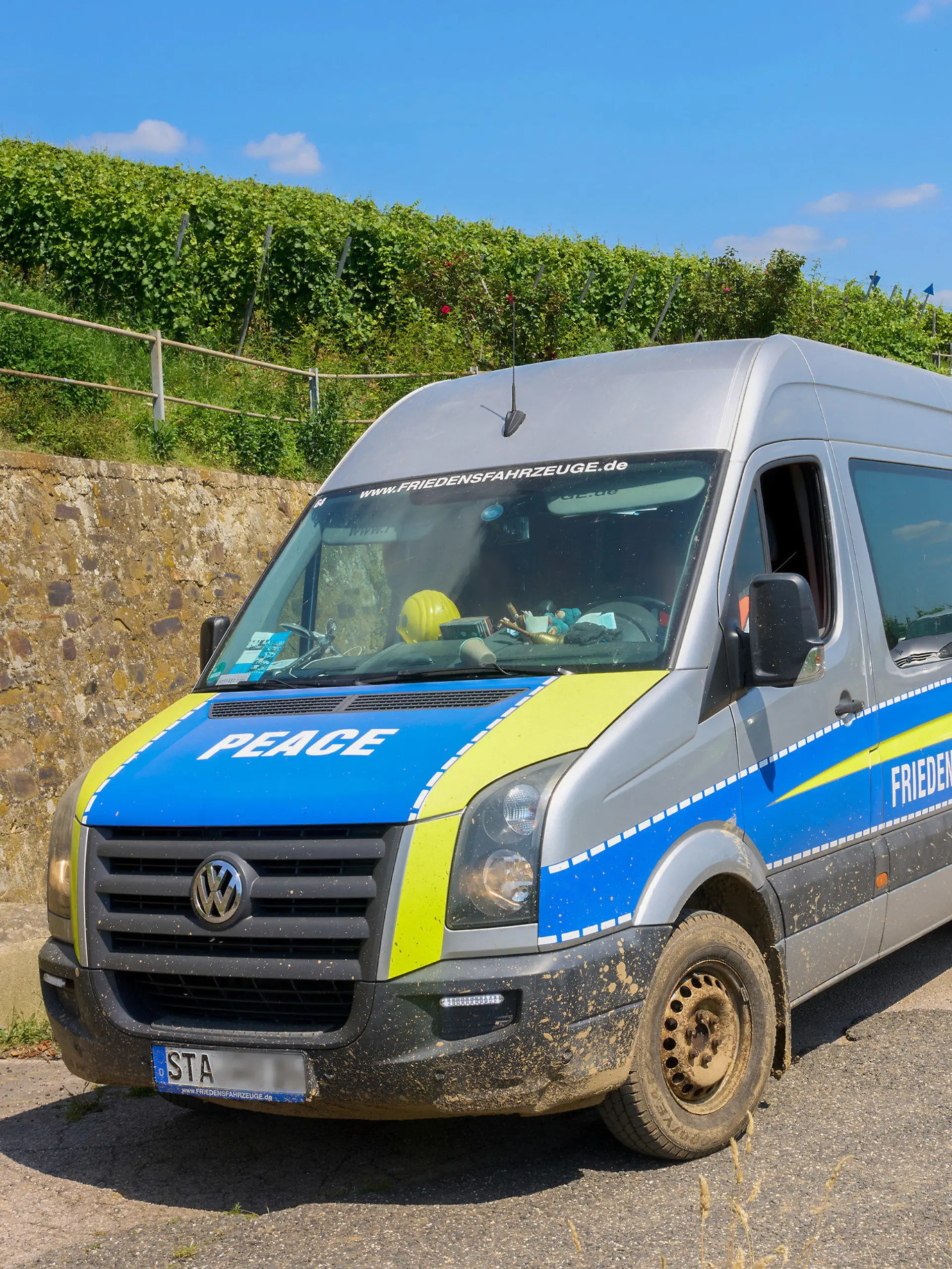 21.07.2021, Rheinland-Pfalz, Ahrweiler: Ein Transporter mit der Aufschrift "Friedensfahrzeug" fährt am Rand des Katastrophengebiets in den Weinbergen entlang. (zu dpa "Polizei hat «Querdenker» im Katastrophengebiet im Blick") Foto: Thomas Frey/dpa +++ dpa-Bildfunk +++