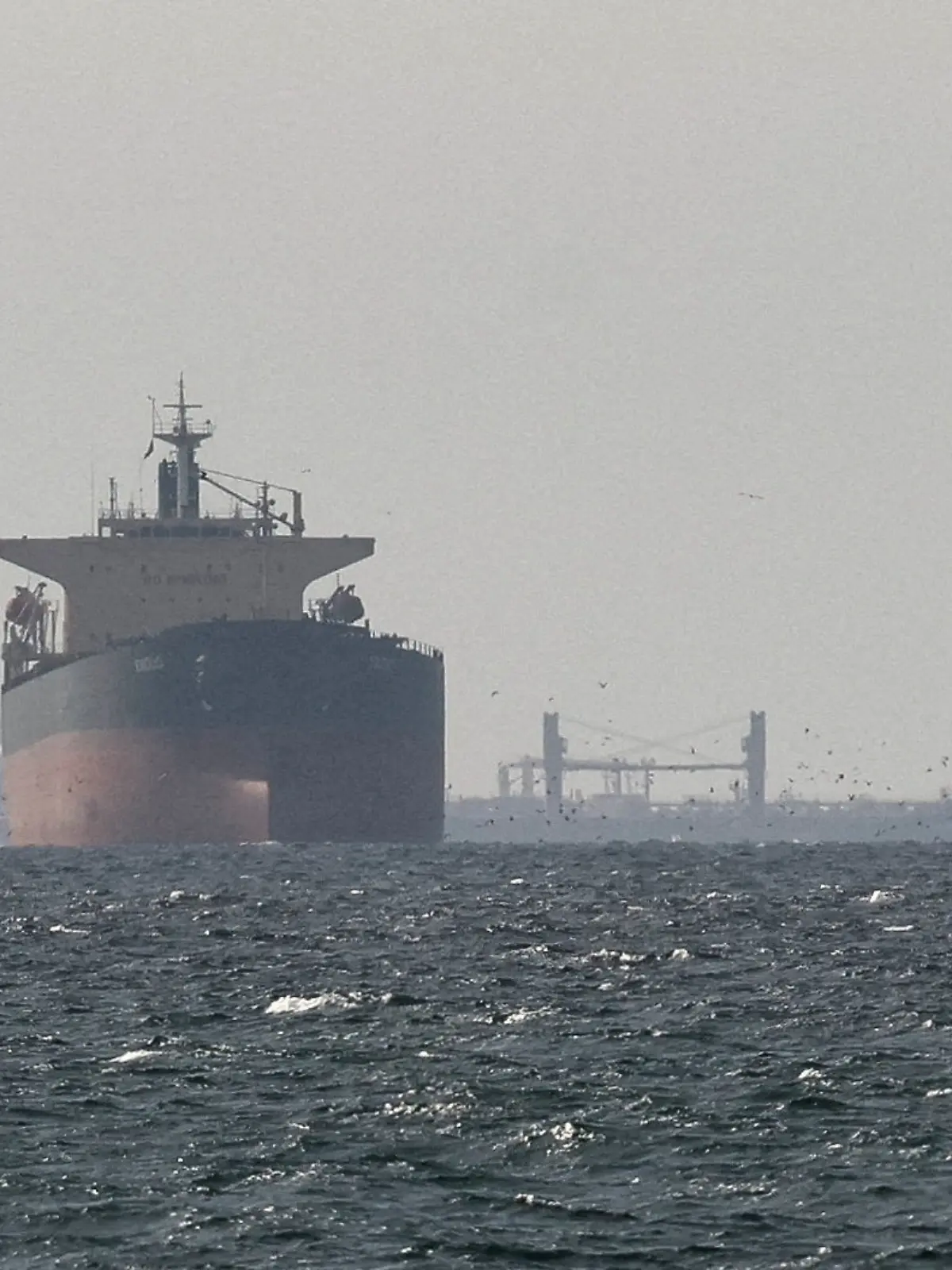 FILE PHOTO: Cargo ships in the Gulf, near the Strait of Hormuz, as seen from northern Ras al-Khaimah, near the border with Oman’s Musandam governance, amid the U.S.-Israeli conflict with Iran, in United Arab Emirates, March 11, 2026. REUTERS/Stringer/File Photo REFILE - CORRECTING "TANKERS" TO "CARGO SHIPS" AND REMOVING ACTION "SAIL".