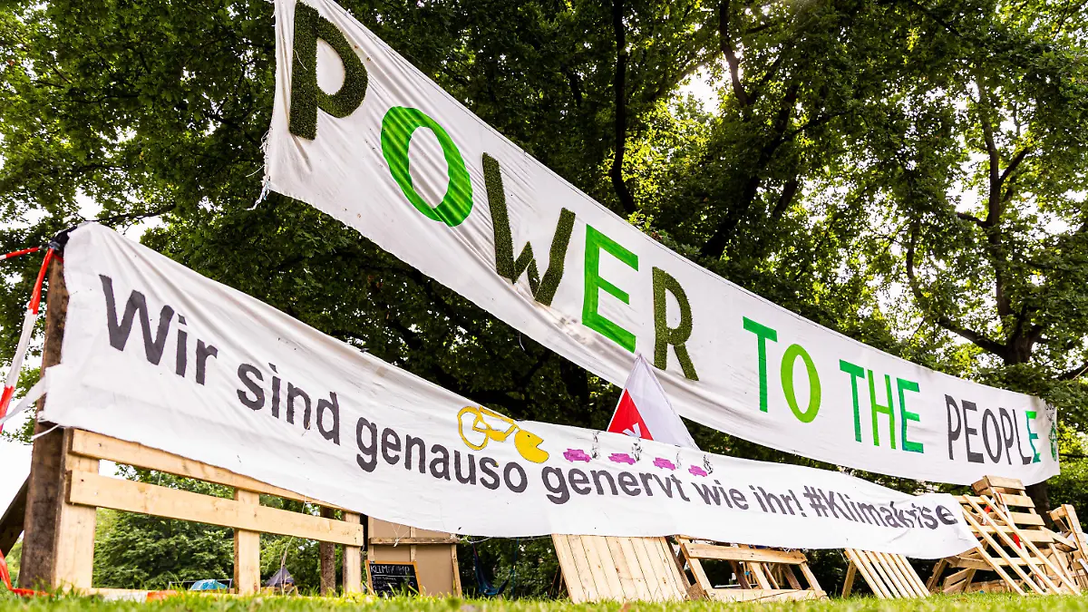 21.07.2021, Niedersachsen, Hannover: Transparente mit der Aufschrift «Power to the people» und «Wir sind genauso genervt wie ihr! #Klimakrise» sind am Rande vom Protestcamp der Bewegung «Fridays for Future» im Maschpark zu sehen. Die Umweltaktivisten fordern mehr Einsatz für den Klimaschutz. Foto: Moritz Frankenberg/dpa +++ dpa-Bildfunk +++
