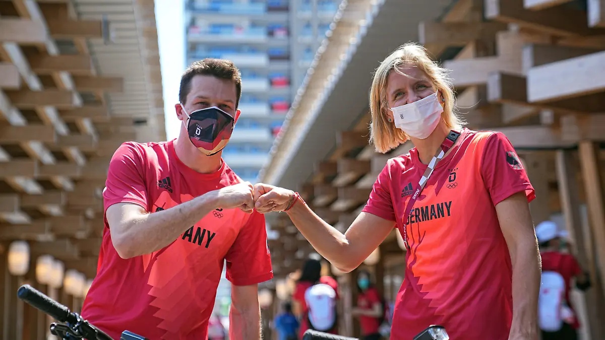 dpatopbilder - 22.07.2021, Japan, Tokio: Wasserspringer Patrick Hausding (l) und Beachvolleyballspielerin Laura Ludwig begrüßen sich vor der Pressekonferenz vom Deutschen Olympischen Sportbund (DOSB) zur Vorstellung des Fahnenträger-Duos vom Team Deutschland für die Eröffnungsfeier der Olympischen Spiele 2020 Tokio. Laura Ludwig und Patrick Hausding werden das deutsche Olympia-Team bei der Eröffnungszeremonie am Freitag (23.07.2012) als Fahnenträger ins Kasumigaoka National Stadium in Tokio führen. Foto: Michael Kappeler/dpa +++ dpa-Bildfunk +++