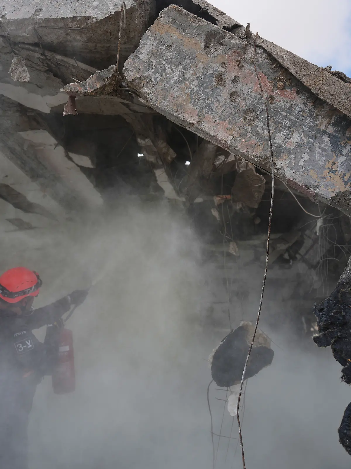 Feuerwehrleute arbeiten daran, das Feuer an der Stelle zu löschen, die von einer iranischen Rakete getroffen wurde. +++ dpa-Bildfunk +++