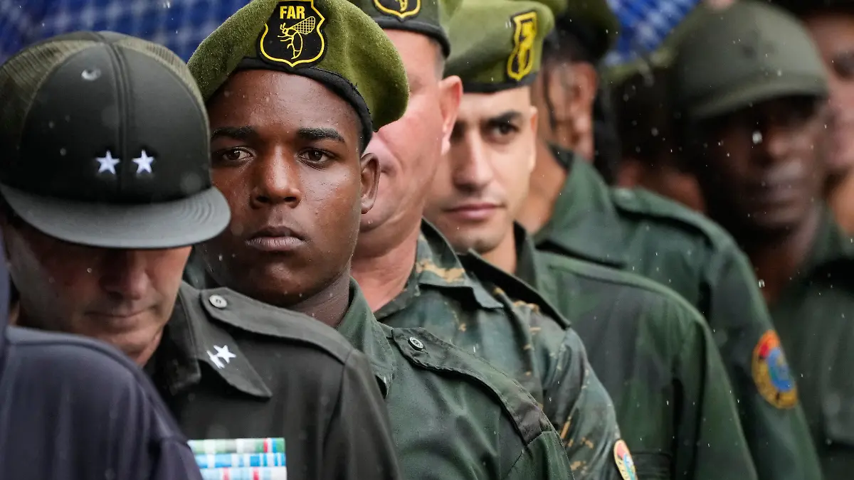 Military members line up outside the Ministry of the Revolutionary Armed Forces where the urns containing the remains of Cuban officers, killed during the U.S. operation in Venezuela that captured President Nicolas Maduro, are on display in Havana, Cuba, Thursday, Jan. 15, 2026. (AP Photo/Ramon Espinosa)