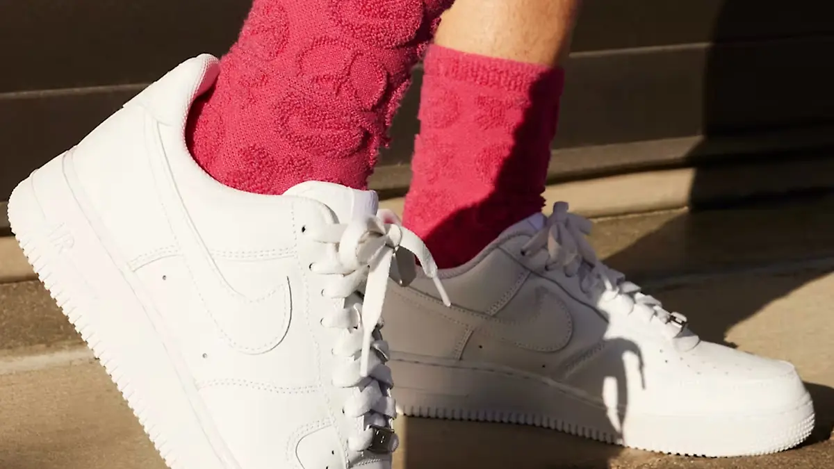 Frau mit flauschigen Socken trägt die Nike Air Force 1 Sneaker.