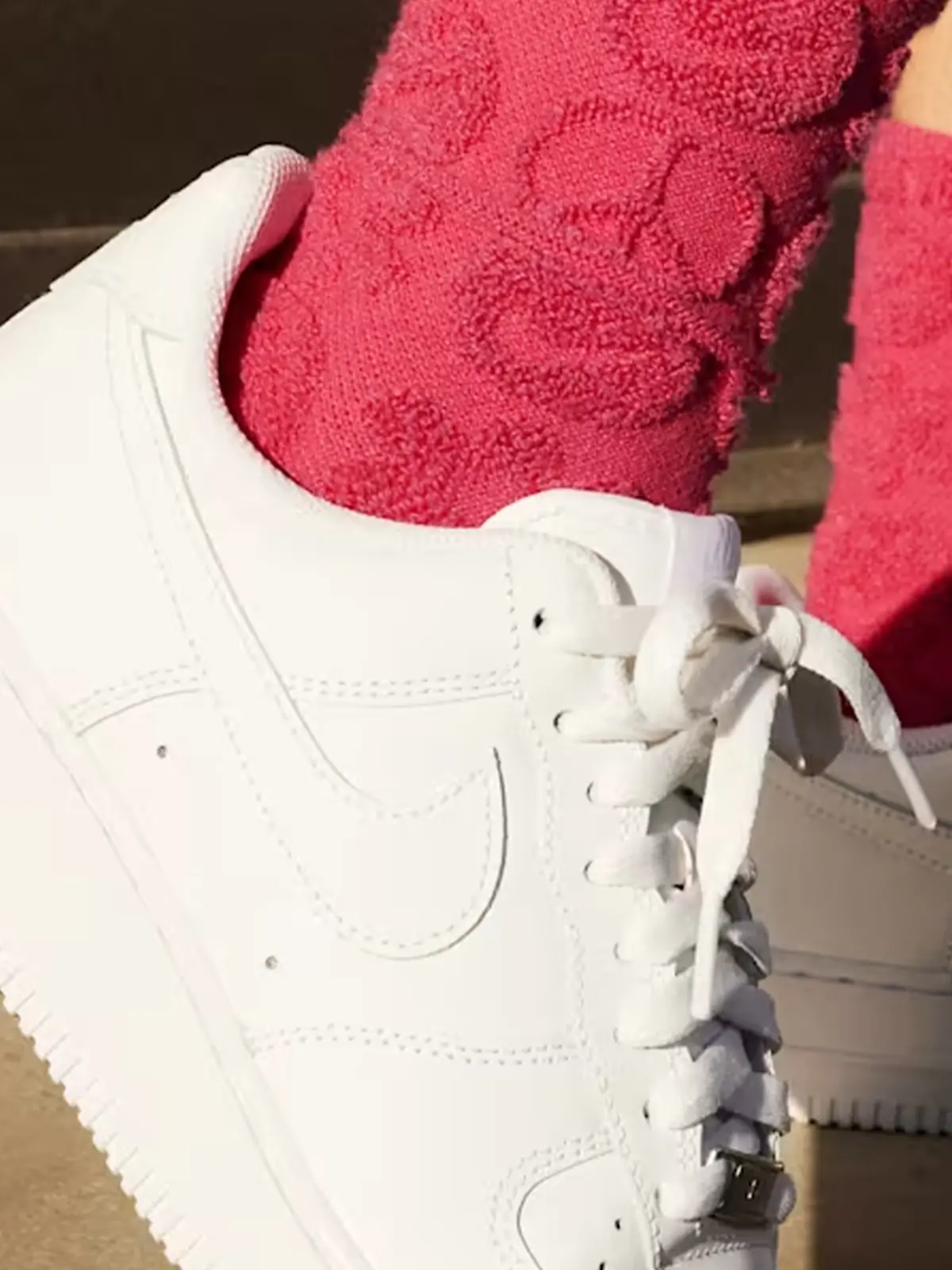 Frau mit flauschigen Socken trägt die Nike Air Force 1 Sneaker.