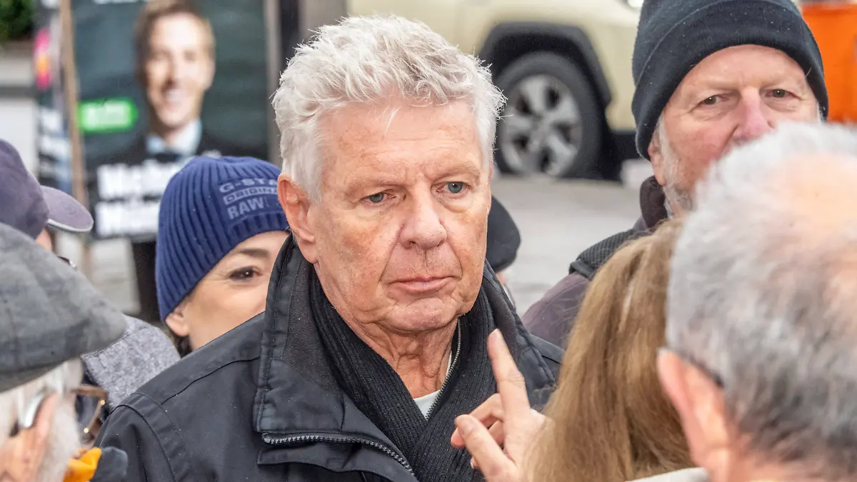 OB Dieter Reiter, SPD, bei Wahlkampftermin im Gespräch mit Bürgern, er tritt in der Stichwahl gegen Dominik Krause von den Grünen an, dessen Wahlplakat im Hintergrund zu sehen ist, München, 17. März 2026 Deutschland, München, 17. März 2026, Dieter Reiter, SPD, bei Wahlkampftermin umringt von Bürgern, Reiter ist Münchner Obürgermeister, steht jetzt in der Stichwahl gegen Dominik Krause, Die Grünen, der ihm auf dem Wahlplakat hinten über die Schulter schaut, OB Reiter am Dienstagmorgen ab 9:30 Uhr am Busbahnhof Kieferngarten im Gespräch mit Passanten, Wahlkampfveranstaltung, Münchner Kommunalwahlkampf, Stichwahl am 22. März, Politiker, Politik, Wahlkampf, Bayern *** Mayor Dieter Reiter, SPD, talking to citizens at an election