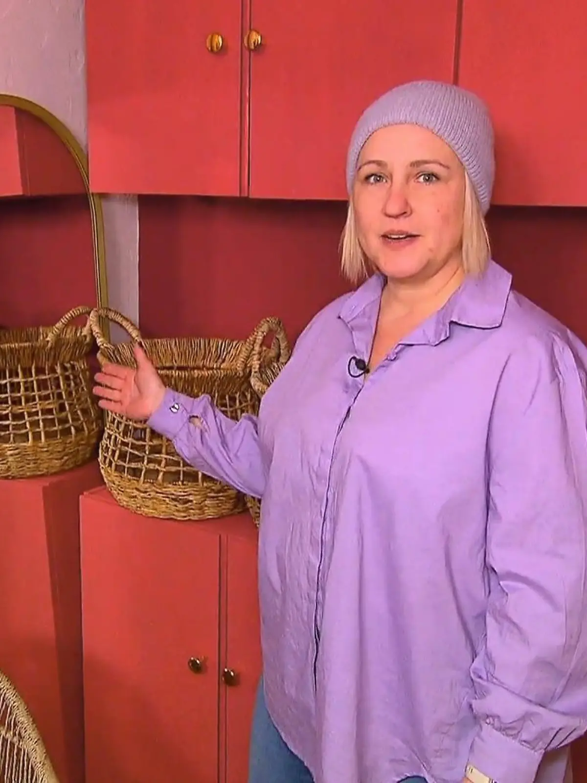 Guidos Deko Queen: Kandidatin Inga in lilafarbener Bluse und Mütze vor einem roten Schrank