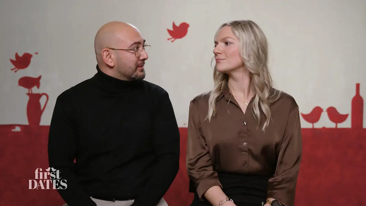 First Dates: Ein Mann mit Glatze, Brille und Bart und eine Frau mit langen blonden Haaren sitzen nebeneinander und schauen sich an