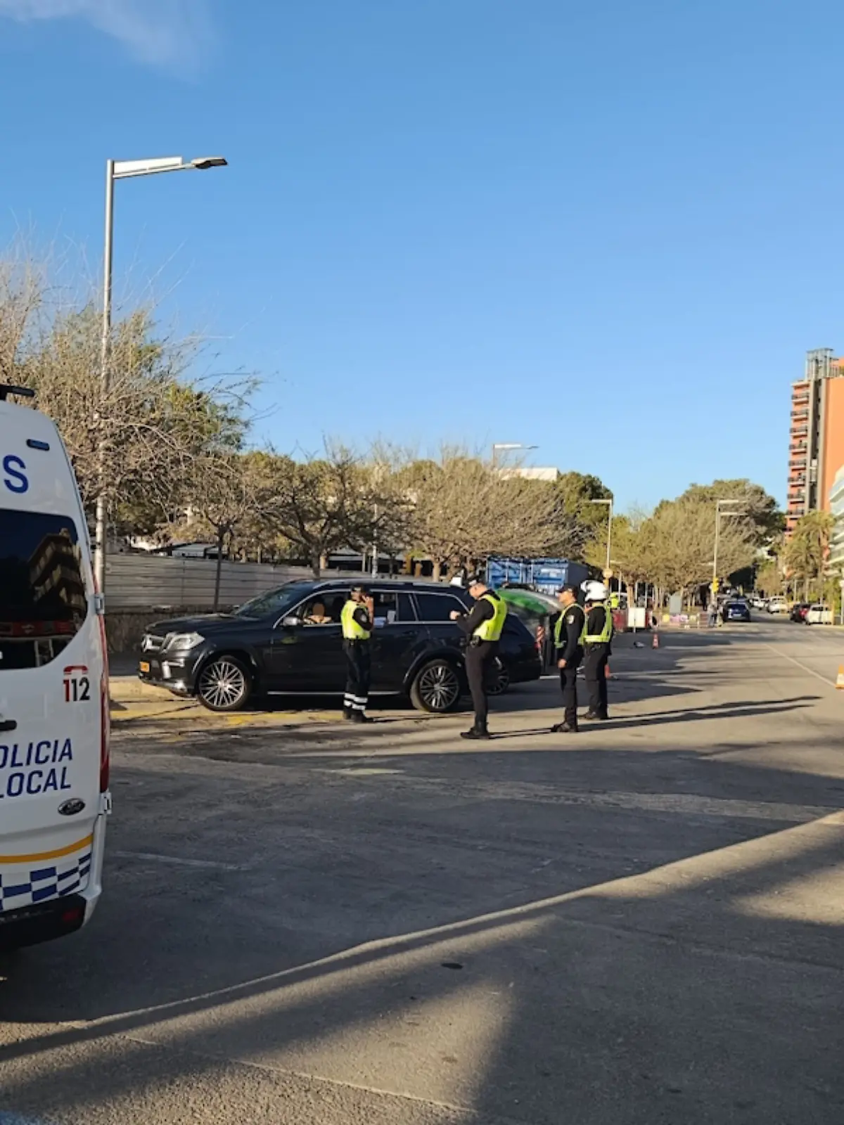 Ein Polizeiwagen in Palma de Mallorca blockiert die Straße, dahinter kontrollierende Beamte.