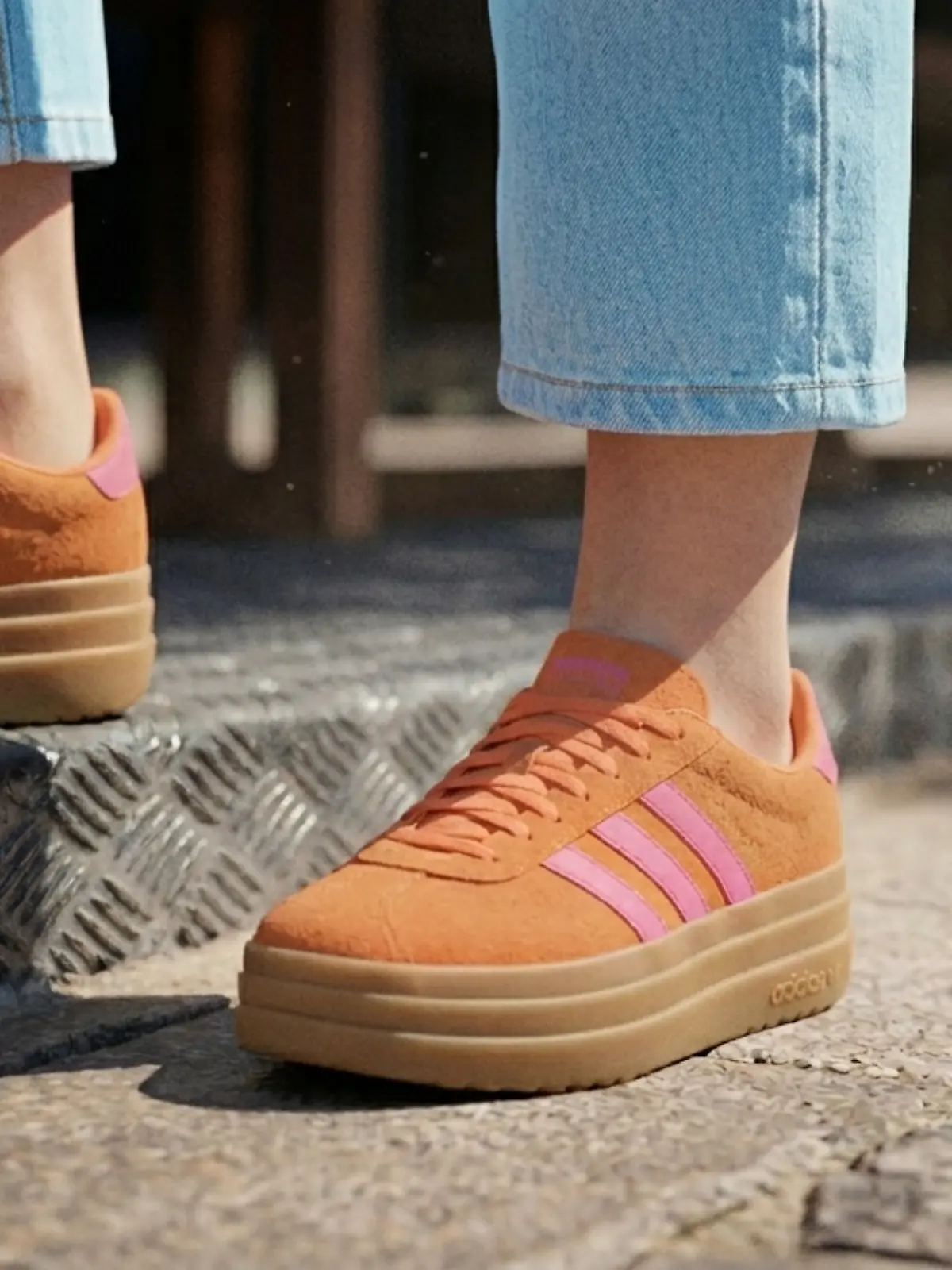 Ein Modell trägt die Adidas VL Court Bold Schuhe.