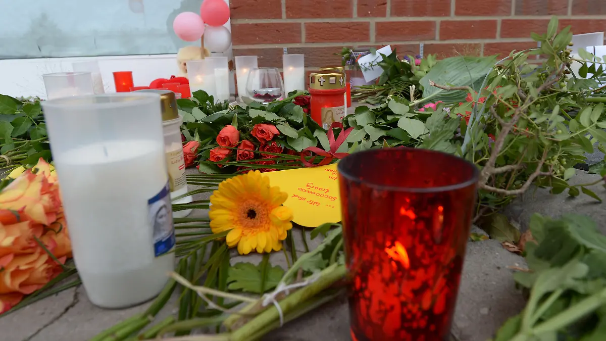 ARCHIV - Blumen, Kerzen und kleine Briefchen liegen am 20.09.2013 vor einem Getränkemarkt in Rethem bei Soltau (Niedersachsen) in dem es zu einem tödlichen Überfall kam. Im Prozess gegen einen Schüler, dem vorgeworfen wird bei einem Überfall auf einen Getränkemarkt eine 23-jährige Frau erstochen zu haben, wird am 24.10.2014 das Urteil erwartet. Foto: Peter Steffen/dpa (zu lni vom 24.10.2014) +++ dpa-Bildfunk +++