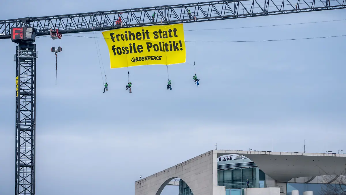 Aktivisten der Umweltschutzorganisation Greenpeace hängen mit einem Transparent „Freiheit statt fossile Politik“ an einem Kran auf dem Gelände des Bundeskanzleramtes.