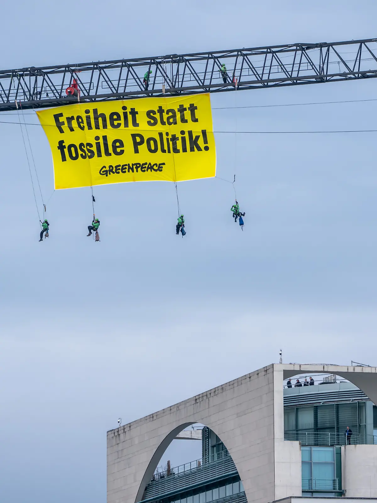 Aktivisten der Umweltschutzorganisation Greenpeace hängen mit einem Transparent „Freiheit statt fossile Politik“ an einem Kran auf dem Gelände des Bundeskanzleramtes.