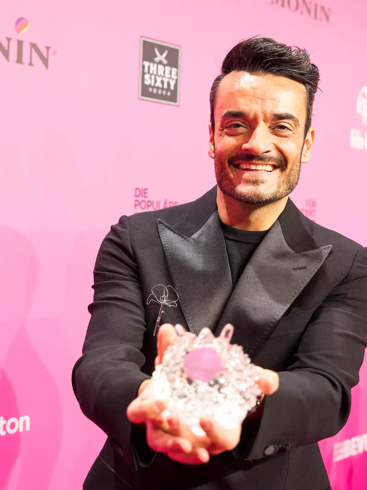 Giovanni Zarrella präsentiert seinen Preis auf dem Roten Teppich nach der Preisverleihung des Polyton 2026 in den Berliner Atelier Gardens am 25.03.2026.