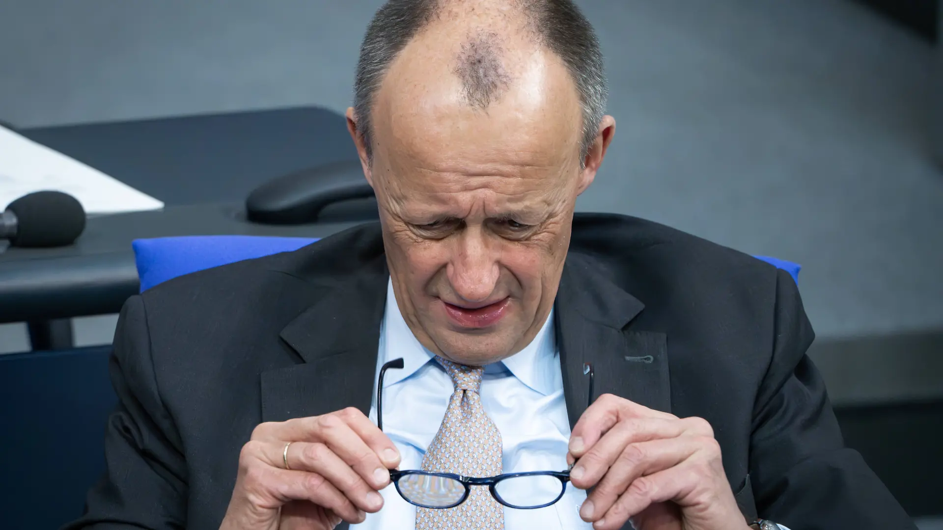 Bundeskanzler Friedrich Merz CDU schaut durch seine Brille auf der Regierungsbank bei der 68. Sitzung des Deutschen Bundestag in Berlin
