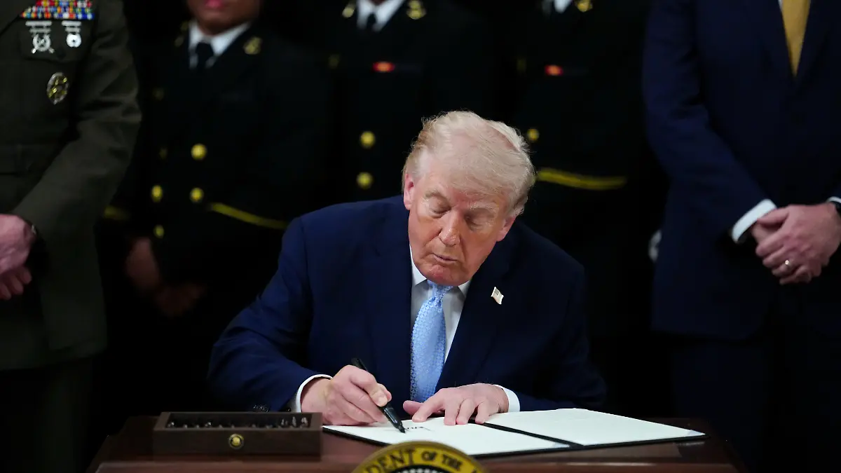 US-Präsident Donald Trump unterzeichnet eine Durchführungsverordnung während einer Veranstaltung zur Verleihung der Commander-in-Chief's Trophy mit dem Navy Midshipmen Football-Team im East Room des Weißen Hauses. +++ dpa-Bildfunk +++