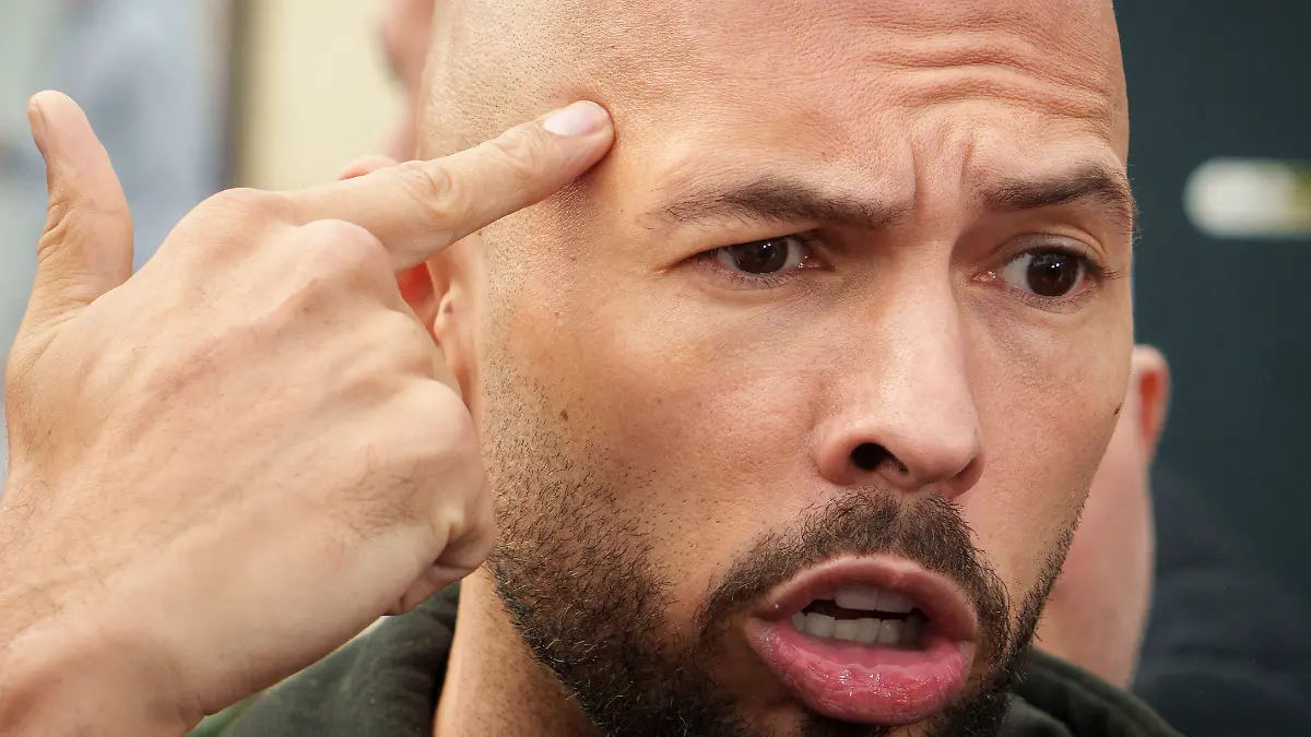 Andrew Tate reacts while speaking to media after checking in at a police station as part of his judicial control, which requires him to appear before judicial authorities in Romania when summoned, in Voluntari, Romania, Monday, March 24, 2025. (AP Photo/Vadim Ghirda)