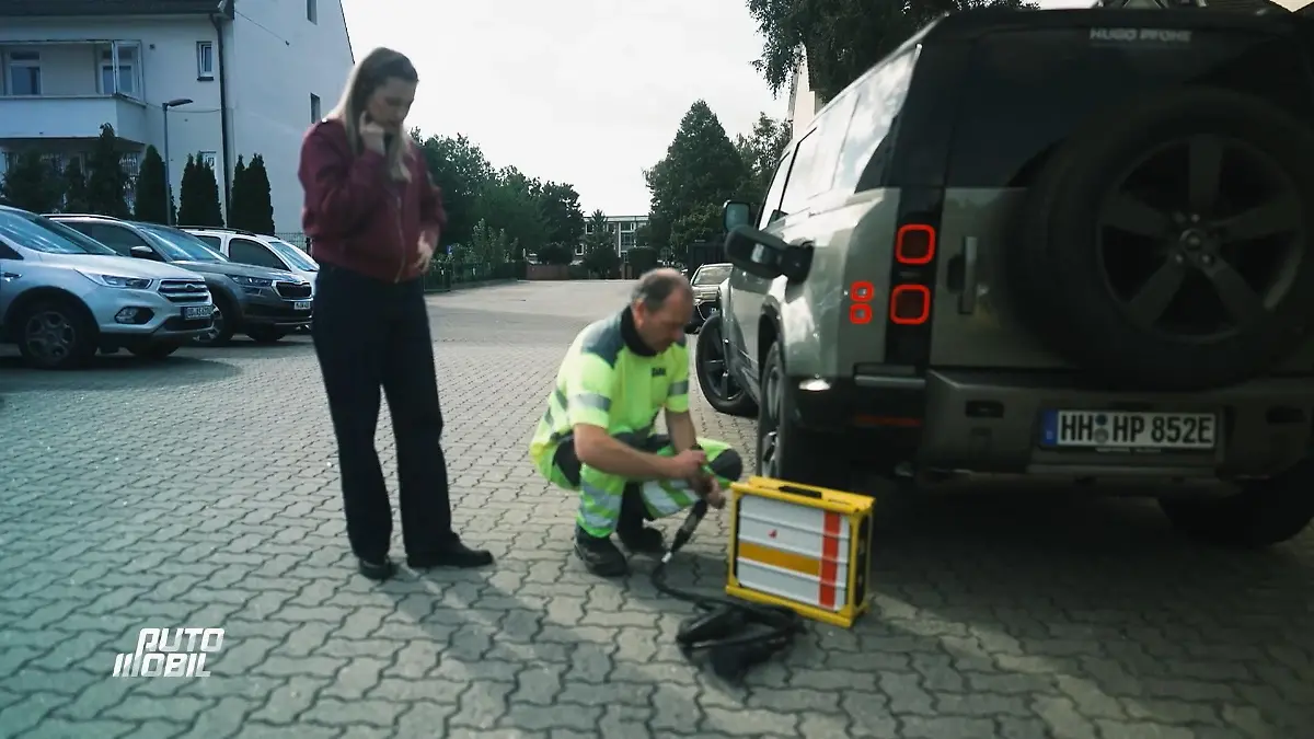auto mobil: Moderatorin Anni Dunkelmann schaut einem Pannenhelfer beim Laden eines E-Auto-Akkus zu