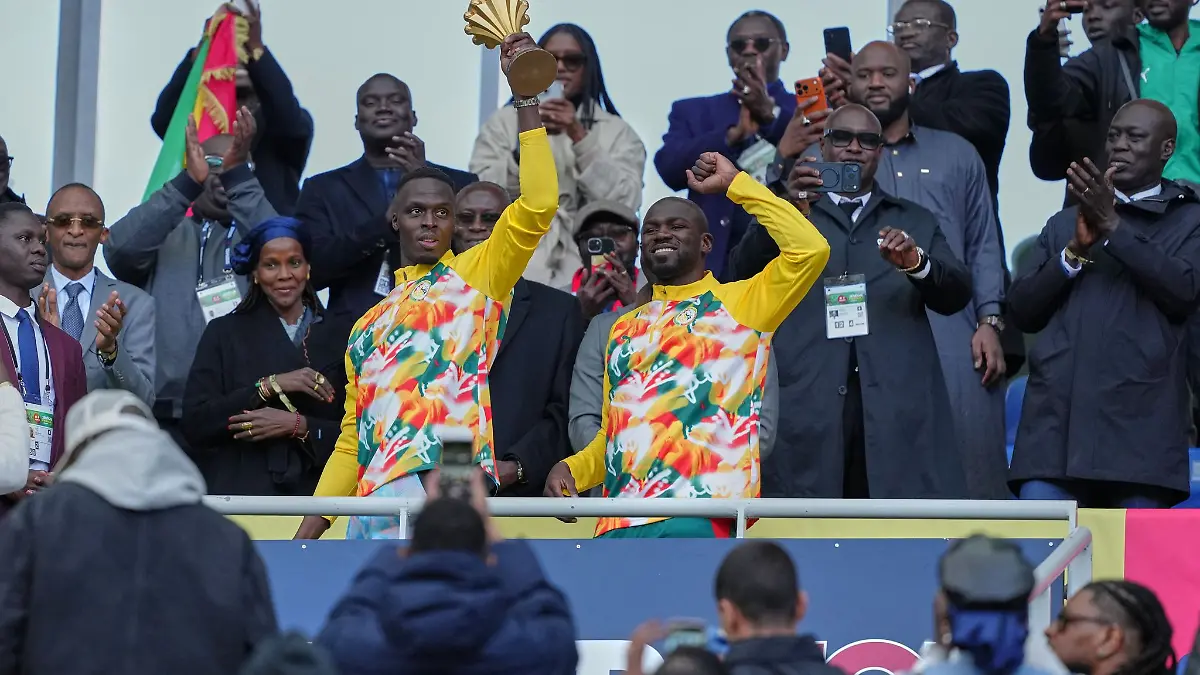 Senegalesische Spieler feiern mit der Afrika-Cup-Trophäe vor dem Spiel.