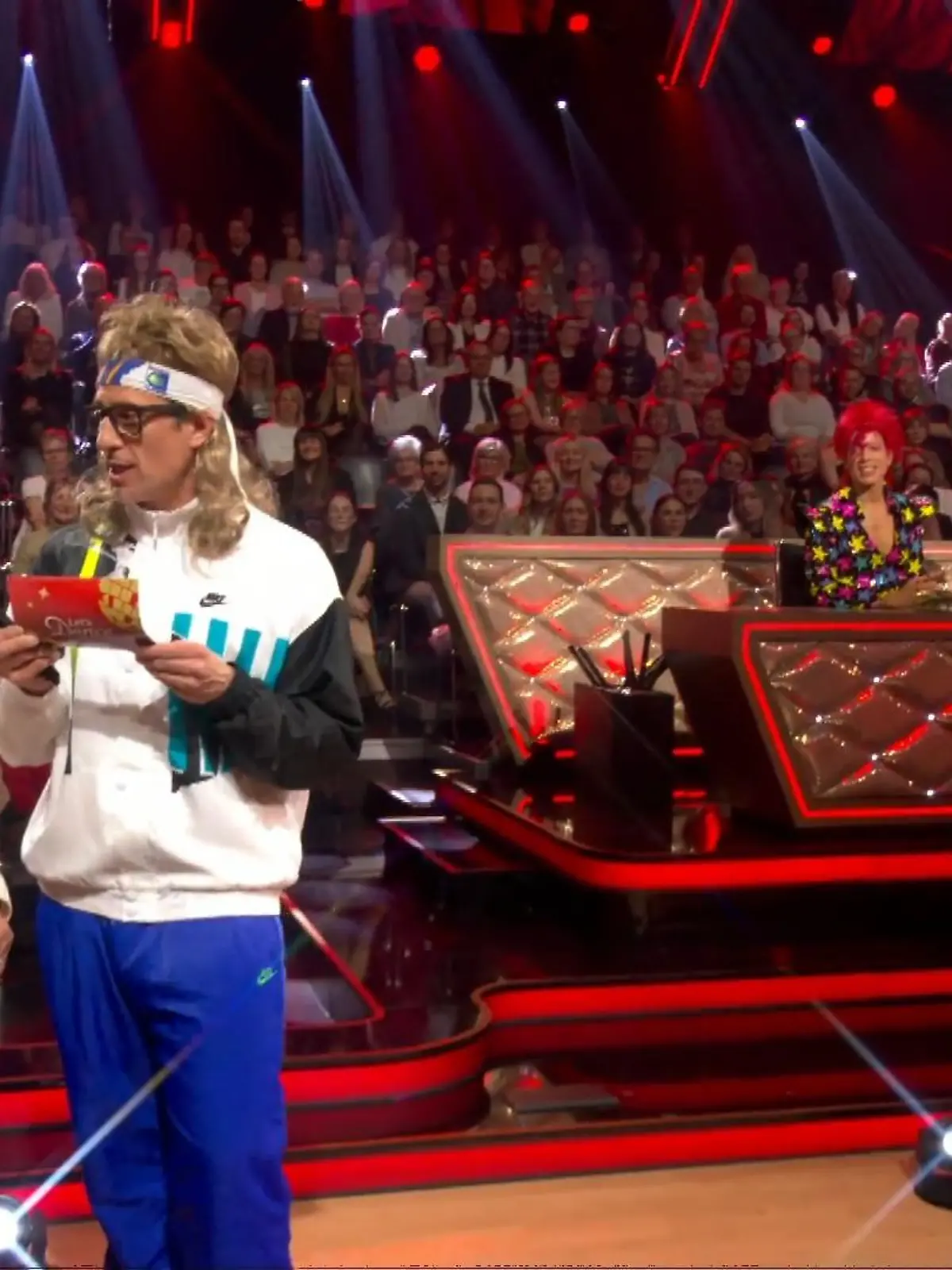 Bild zu: "Barbara aus Hürth darf den Ergebnisumschlag abholen"