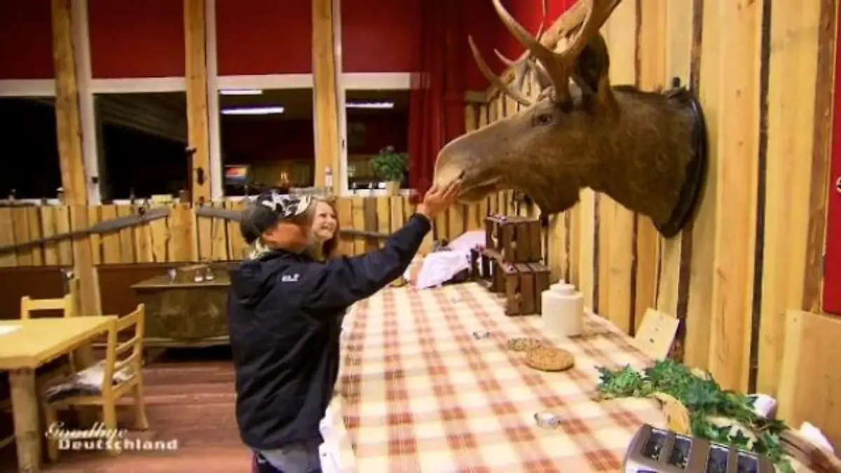 Goodbye Deutschland - Die Auswanderer: Frau mit Käppi und ihre Tochter bestaunen einen ausgestopften Elchkopf an der Wand