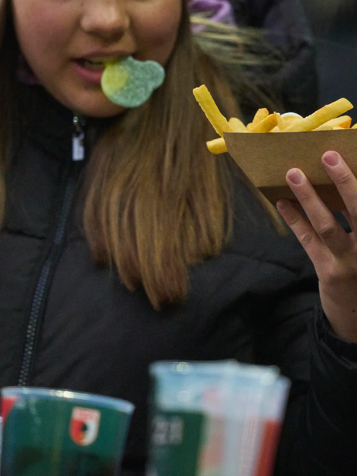 Spectator with food and beer in the match FC AUGSBURG - VFL WOLFSBURG 1-0 on Mar 15, 2025 in Augsburg, Germany. Season 2024/2025, 1.Bundesliga, FCA, matchday 26, 26.Spieltag Photographer: Peter Schatz - DFL REGULATIONS PROHIBIT ANY USE OF PHOTOGRAPHS as IMAGE SEQUENCES and/or QUASI-VIDEO -