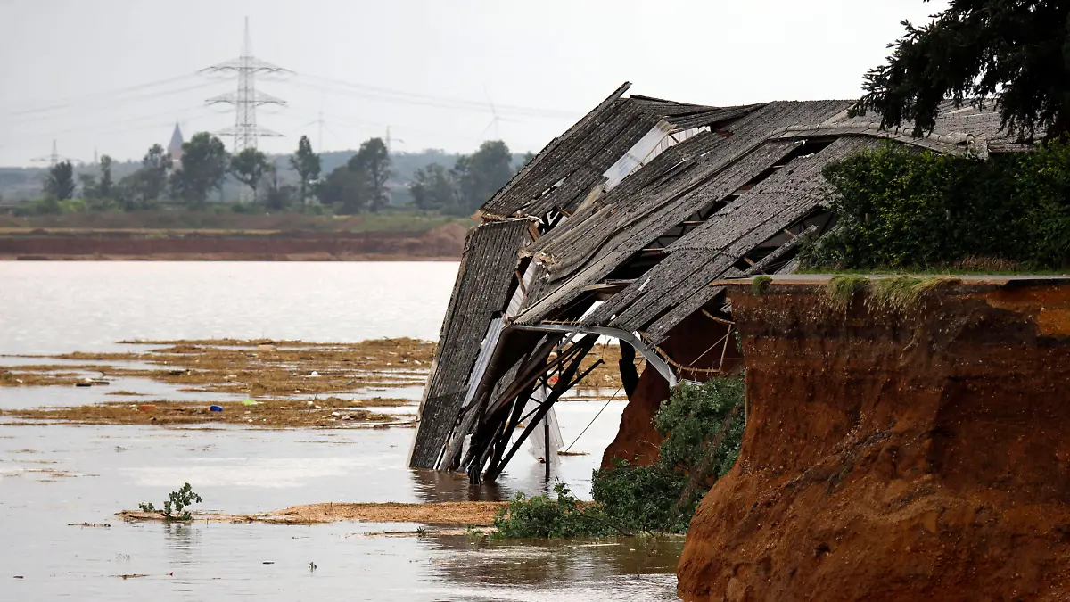 News Bilder des Tages In Erftstadt-Blessem NRW sind Häuser massiv unterspült worden und einige eingestürzt oder in eine nahe Kiesgrube gestürzt. An deren Rand hatte sich wasserbedingt ein Krater gebildet, der umliegende Felder immer weiter in die Kiesgrube rutschen ließ. Es werden etliche Personen vermisst. Noch mehr Häuser drohen abzurutschen. Der Katastrophenschutz ist vor Ort. Im Bild abgestürzte Teile einer Reithalle in Blessem. Blessem, 16.07.2021 *** In Erftstadt Blessem NRW houses have been massively washed out and some have collapsed or fallen into a nearby gravel pit A crater had formed at the edge of the pit due to the water, causing surrounding fields to slide further and further into the gravel pit Several people are missing Even more houses Foto:xC.xHardtx/xFuturexImage