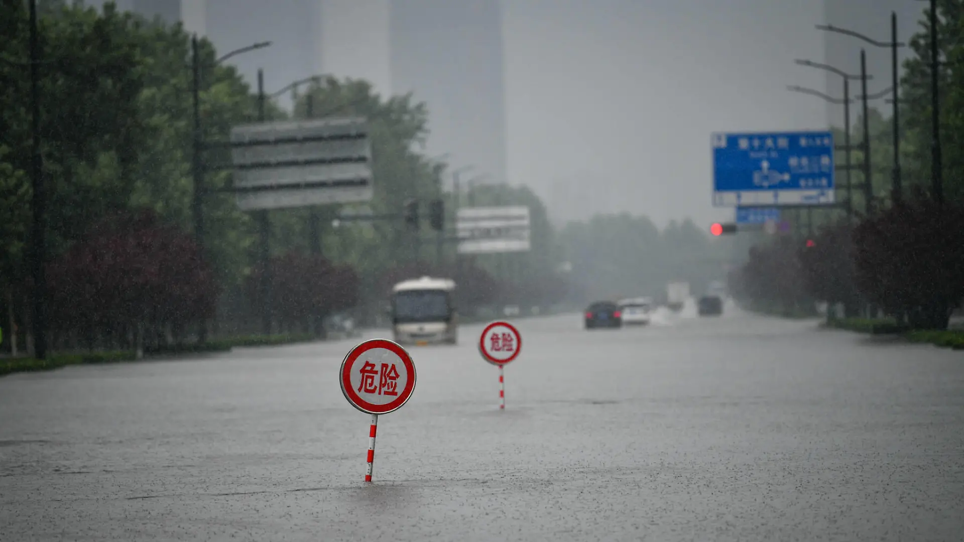 210720 -- ZHENGZHOU, July 20, 2021 -- Danger signs are installed on a waterlogged road in Zhengzhou, capital of central China s Henan Province, July 20, 2021. More than 144,660 residents have been affected by torrential rains in central China s Henan Province since July 16, and 10,152 have been relocated to safe places, the provincial flood control and drought relief headquarters said Tuesday. A total of 16 large and medium-sized reservoirs have seen water levels rise above the alert level after torrential rains battered most parts of the province on Monday and Tuesday. Photo by Hou Jianxun/Xinhua CHINA-HENAN-ZHENGZHOU-HEAVY RAINFALL CN LixAn PUBLICATIONxNOTxINxCHN