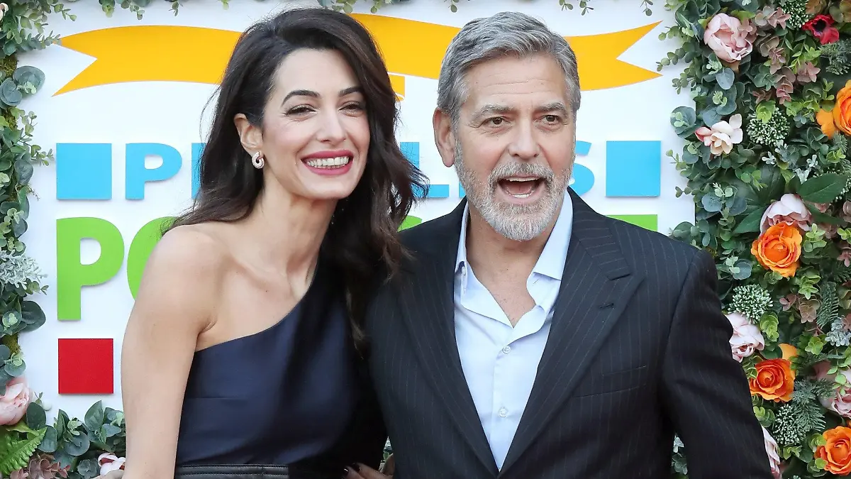 ARCHIV - 14.03.2019, Großbritannien, Edinburgh: George Clooney, Schauspieler aus den USA, und seine Frau Amal Clooney, Juristin aus dem Libanon, treffen für die Wohltätigkeits-Gala der People's Postcode Lottery in der McEwan Hall ein. Er führt Regie, steht vor der Kamera, engagiert sich politisch und macht die Wäsche: Zwillingsvater und Hollywood-Star George Clooney feiert am 06.05.2021 seinen 60. Geburtstag. (zu dpa "Zwillinge und zig Projekte: Hollywood-Star Clooney wird 60" - Wiederholung vom 30.04.2021) Foto: Andrew Milligan/PA Wire/dpa +++ dpa-Bildfunk +++