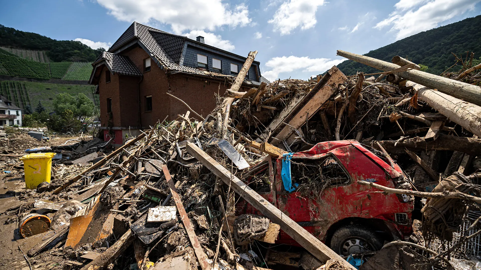 Aufräumarbeiten nach dem Hochwasser Schuttberg mit eingeschlossenen Auto vor Wohnhaus in der Stadt Marienthal. Am 14.07.2021 kam es im Landkreis Ahrweiler zu starken Überflutungen durch Starkregen. Tage nach dem Hochwasser liefen Aufräumarbeiten an. Bundeswehr, Polizei, Feuerwehr und Freiwillige beteiligen sich daran. Marienthal Rheinland-Pfalz Deutschland *** Cleanup after the flood debris mountain with trapped car in front of residential building in the town of Marienthal On 14 07 2021 there was heavy flooding in the district of Ahrweiler due to heavy rain Days after the flood cleanup work was underway Bundeswehr, police, firefighters and volunteers participate Marienthal Rhineland Palatinate Germany