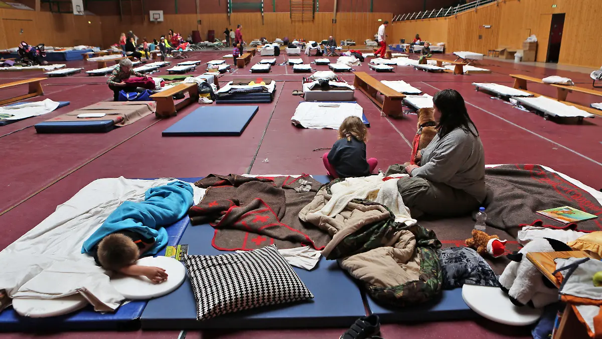 Vor dem Hochwasser in Sicherheit gebrachte Bewohner sitzen am 04.06.2013 in einer als Notunterkunft genutzten Sporthalle in Bitterfeld-Wolfen (Sachsen-Anhalt). Etwa 10 000 Menschen sollen in Bitterfeld ihre Häuser verlassen, um einem möglichen Hochwasser zu entgehen. Nach Angaben der Stadt ist nicht klar, wann und wie stark Wasser aus dem Goitzschesee in die Stadt eindringen wird. Foto: Jan Woitas/dpa +++(c) dpa - Bildfunk+++
