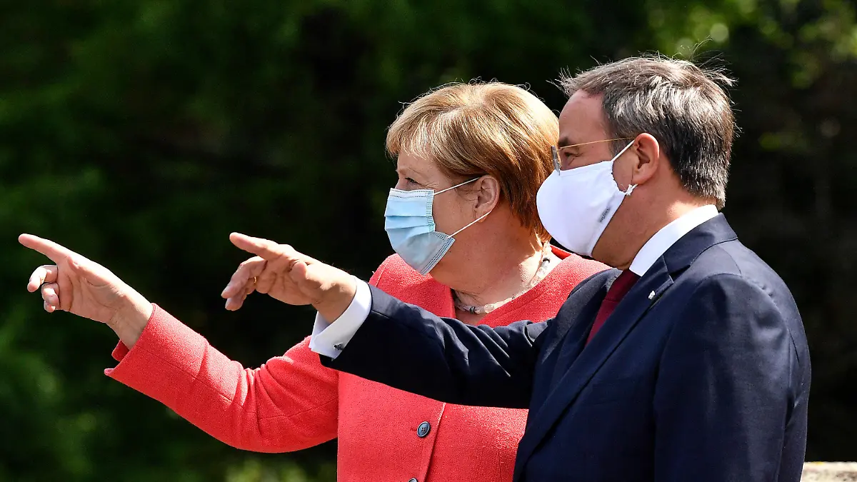 FILE - In this Aug. 18, 2020 file photo, German chancellor Angela Merkel, left, wears a face mask due to the coronavirus pandemic as she meets Governor Armin Laschet, right, during her visit at Germany's most populated federal state North Rhine-Westphalia in Duesseldorf, Germany. Like Merkel, Laschet is known as a centrist favoring integration over polarization. So far, he has been guarded in deviating from her successful middle-of-the-road path on domestic issues.(AP Photo/Martin Meissner, File)