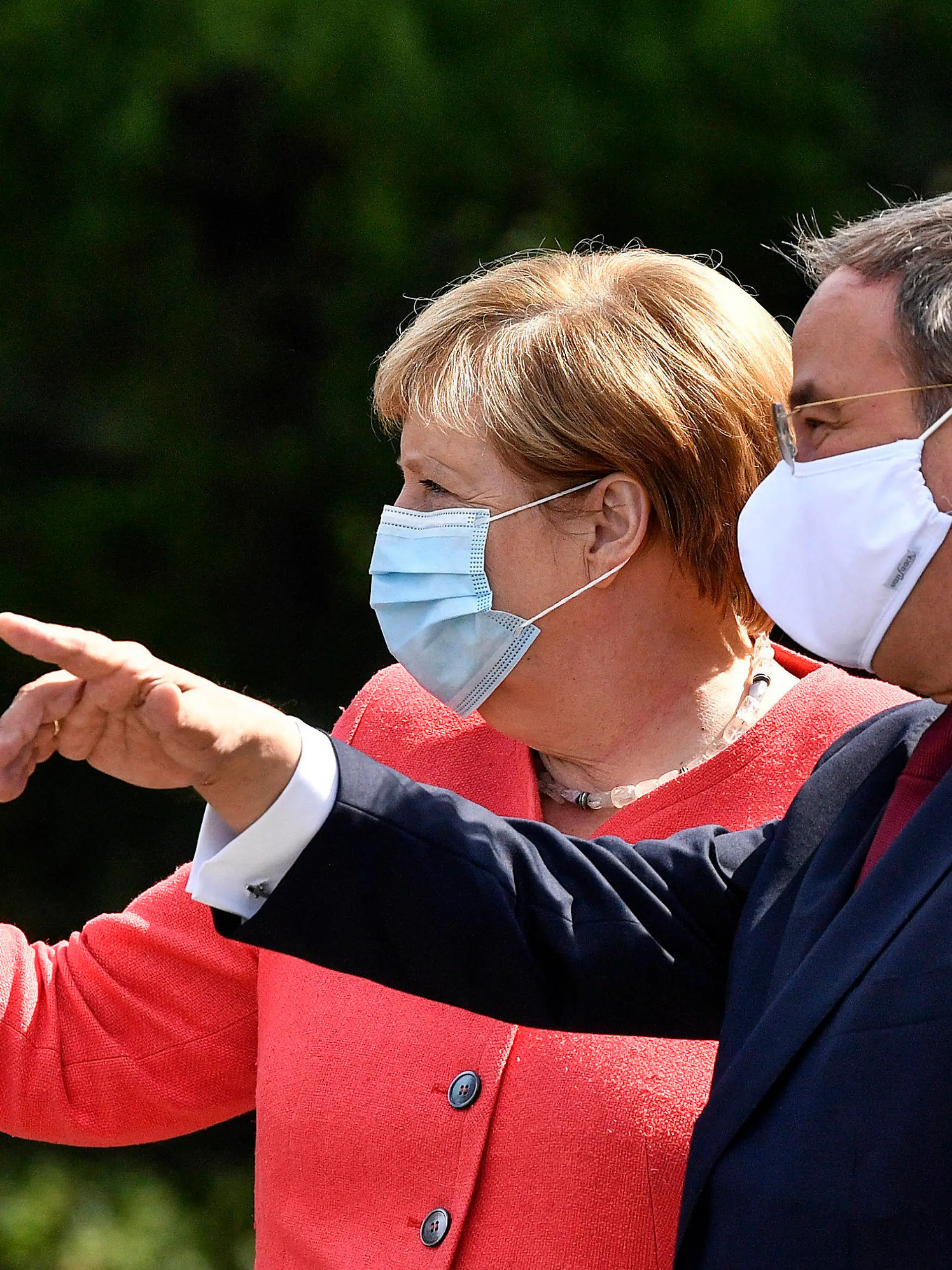FILE - In this Aug. 18, 2020 file photo, German chancellor Angela Merkel, left, wears a face mask due to the coronavirus pandemic as she meets Governor Armin Laschet, right, during her visit at Germany's most populated federal state North Rhine-Westphalia in Duesseldorf, Germany. Like Merkel, Laschet is known as a centrist favoring integration over polarization. So far, he has been guarded in deviating from her successful middle-of-the-road path on domestic issues.(AP Photo/Martin Meissner, File)
