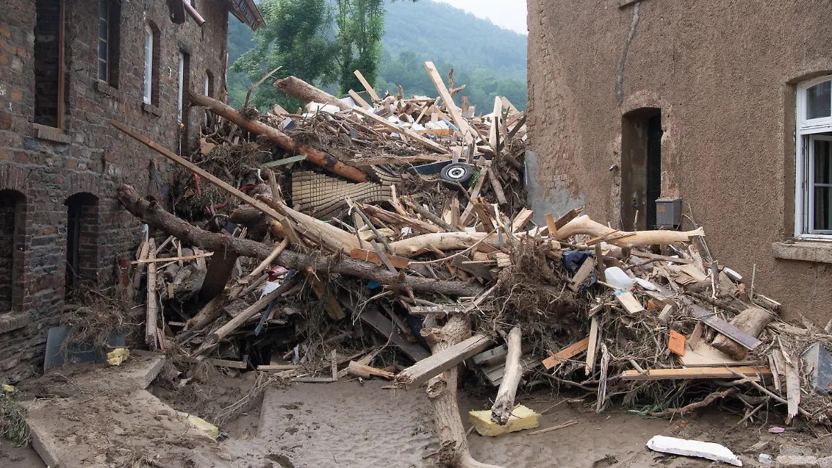 19.07.2021, Rheinland-Pfalz, Altenahr: Meterhoch türmt sich angespülter Unrat zwischen zwei Gebäuden in Altenahr. Zahlreiche Häuser in dem Ort wurden komplett zerstört oder stark beschädigt, es gibt zahlreiche Todesopfer. Foto: Boris Roessler/dpa +++ dpa-Bildfunk +++