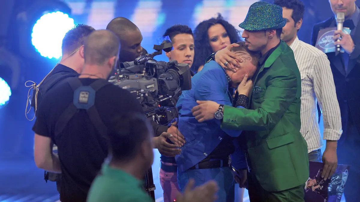 Der Kandidat Mehrzad Marashi (grüner Anzug) spendet dem unterlegenen Menowin Fröhlich (M) nach seinem Sieg im Finale der RTL-Castingshow „Deutschland sucht den Superstar” (DSDS) am Sonntagmorgen (18.04.2010) in Köln Trost. Foto: Jörg Carstensen dpa