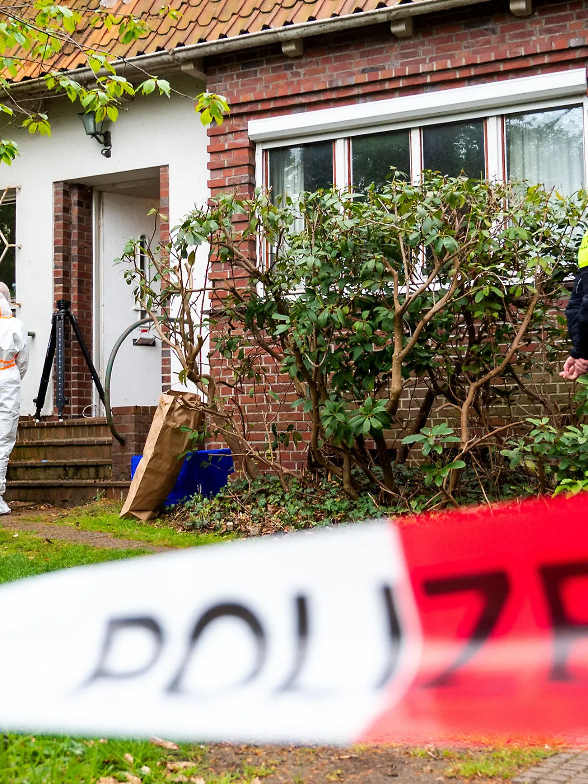 11.05.2023, Hamburg: Polizisten und Mitarbeiter der Spurensicherung stehen im Stadtteil Blankenese vor einem Wohnhaus. Eine Frau ist in Hamburg-Blankenese möglicherweise umgebracht worden. Foto: Daniel Bockwoldt/dpa +++ dpa-Bildfunk +++