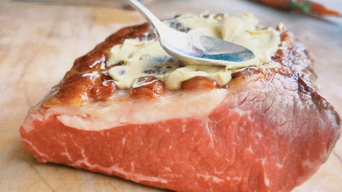 Das Roastbeef wird mit Dijonsenf bestrichen