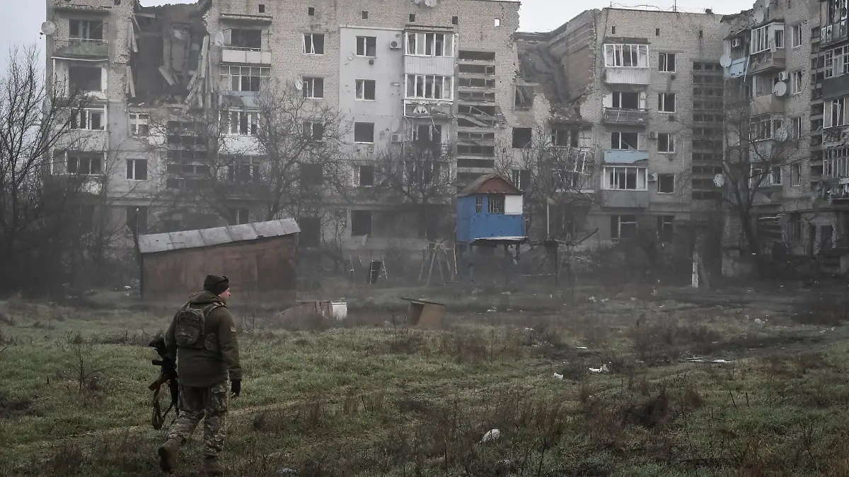 A Ukrainian service member walks near residential buildings damaged by Russian military strikes, amid Russia's attack on Ukraine, in the frontline town Orikhiv in Zaporizhzhia region, Ukraine March 26, 2026. REUTERS/Stringer