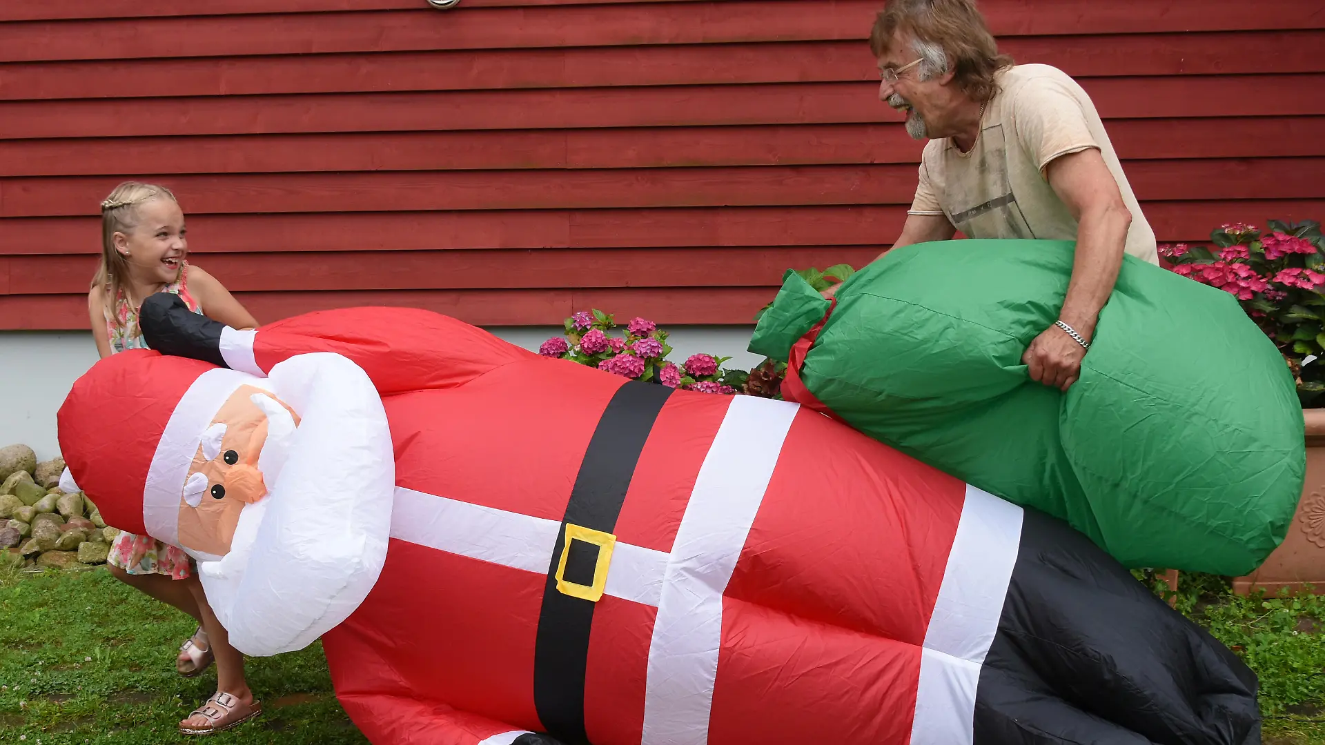 Tochter und Opa bauen Santa im Garten auf