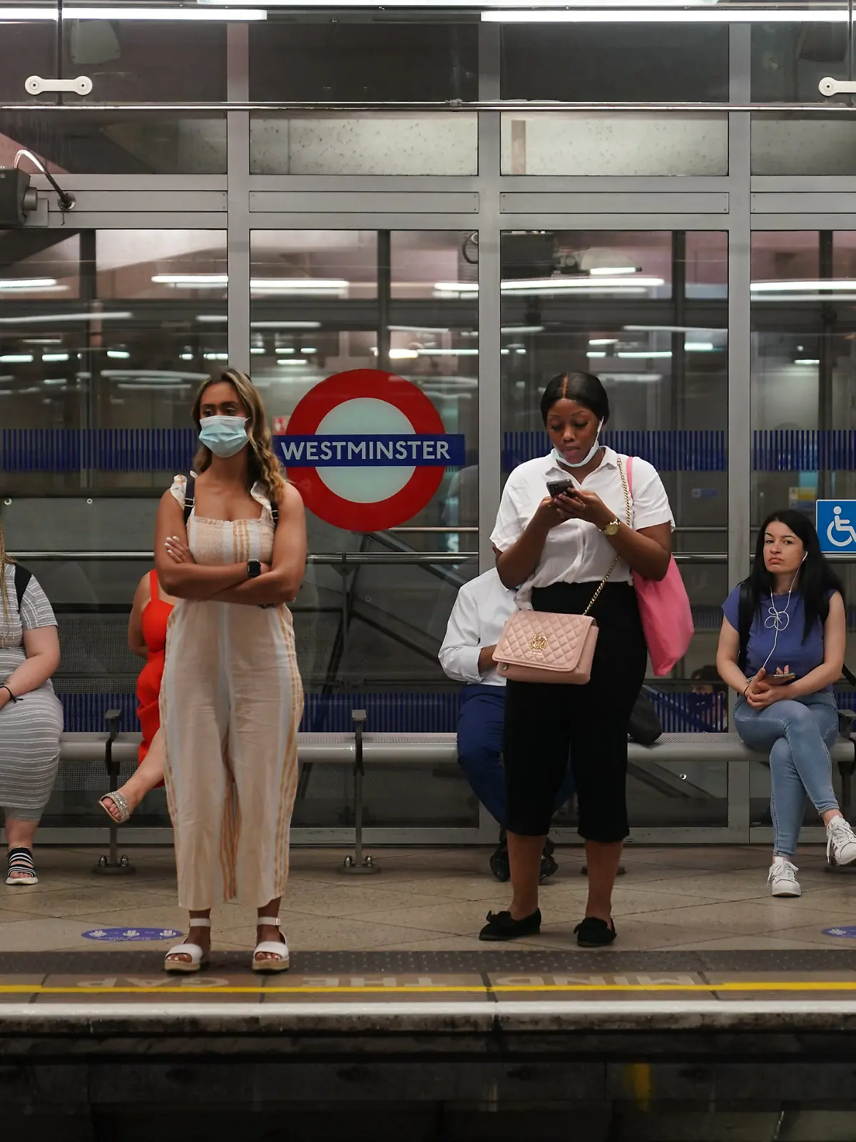 19.07.2021, Großbritannien, London: Pendler, von denen einige keinen Mund-Nasen-Schutz tragen, stehen an der Westminster Underground Station, um 08:34 Uhr, nachdem die letzten Corona-Maßnahmen aufgehoben wurden. Trotz dramatisch steigender Infektionszahlen sind am Montag in England fast alle Corona-Maßnahmen aufgehoben worden. Foto: Yui Mok/PA Wire/dpa +++ dpa-Bildfunk +++
