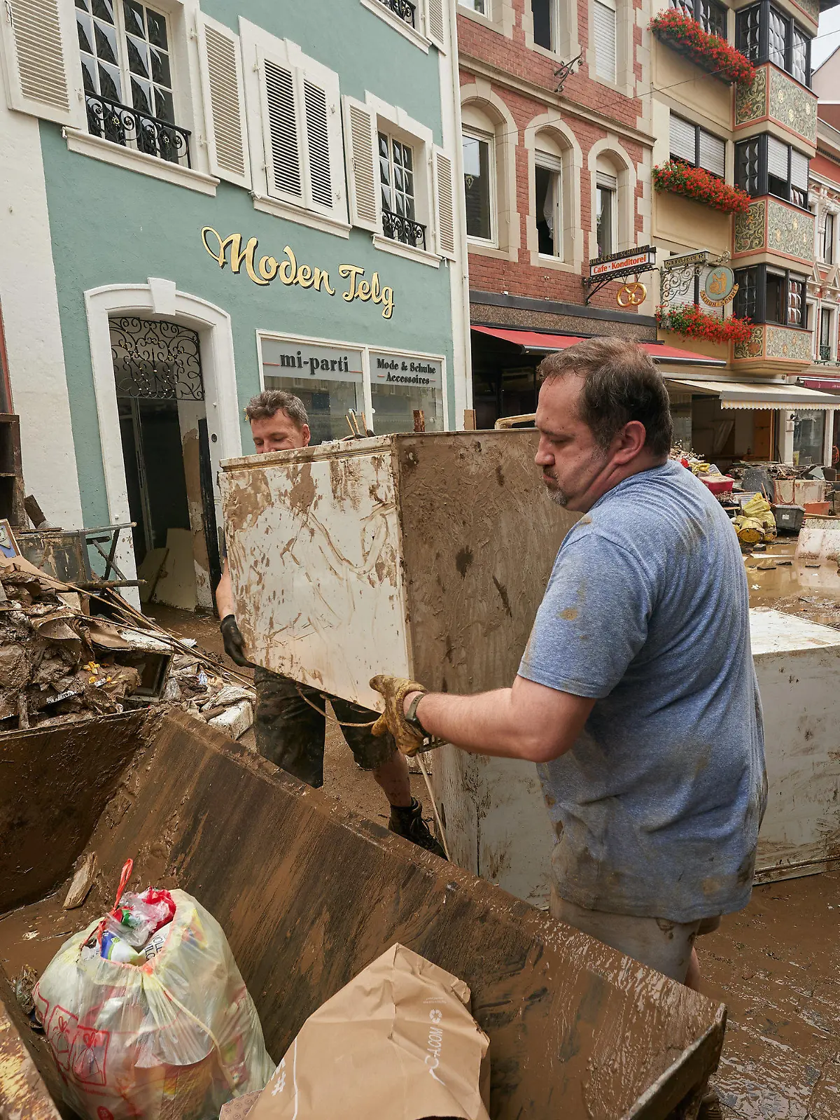 17.07.2021, Rheinland-Pfalz, Ahrweiler: Anwohner und Ladeninhaber versuchen, ihre Häuser vom Schlamm zu befreien und unbrauchbares Mobiliar nach draußen zu bringen. In den vom Unwetter betroffenen Gebieten beginnen die Aufräumungsarbeiten Foto: Thomas Frey/dpa +++ dpa-Bildfunk +++