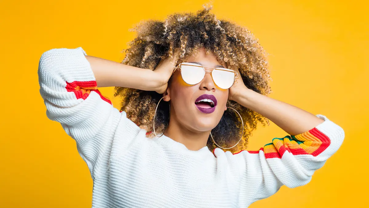 Sternzeichen Löwe: Frau mit Afro trägt Sonnenbrille.