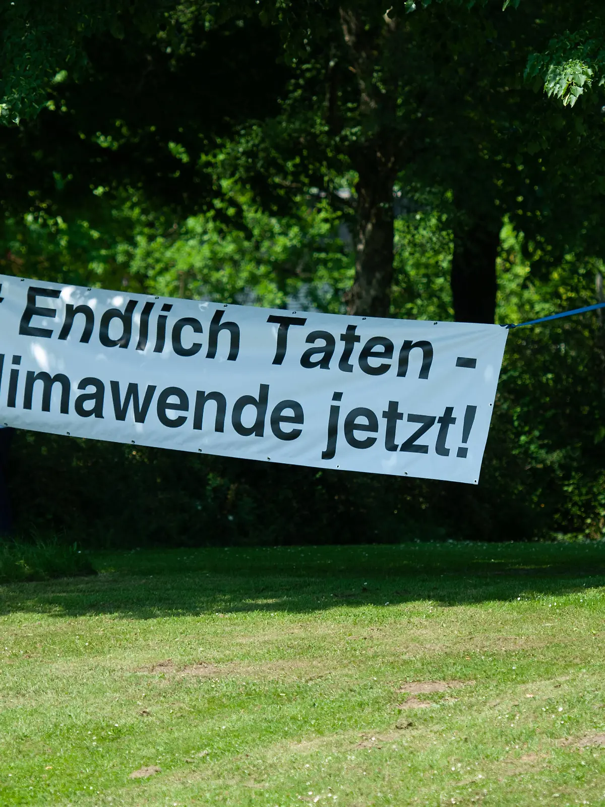 Kundgebung und Demonstration der Aktionsgruppe KLIMA Flensburg Transparent mit Aufschrift Endlich Taten Klimawende jetzt an Bäumen im Carlilse-Park befestigt. Aufnahme vom 18.06.2021, Flensburg, Bahnhofsumfeld, Carlisle-Park, Bahnhofsstraße *** Rally and demonstration of the action group KLIMA Flensburg banner with the inscription Endlich Taten Klimawende jetzt attached to trees in Carlilse Park photo taken 18 06 2021, Flensburg, Bahnhofsumfeld, Carlisle Park, Bahnhofsstraße 
