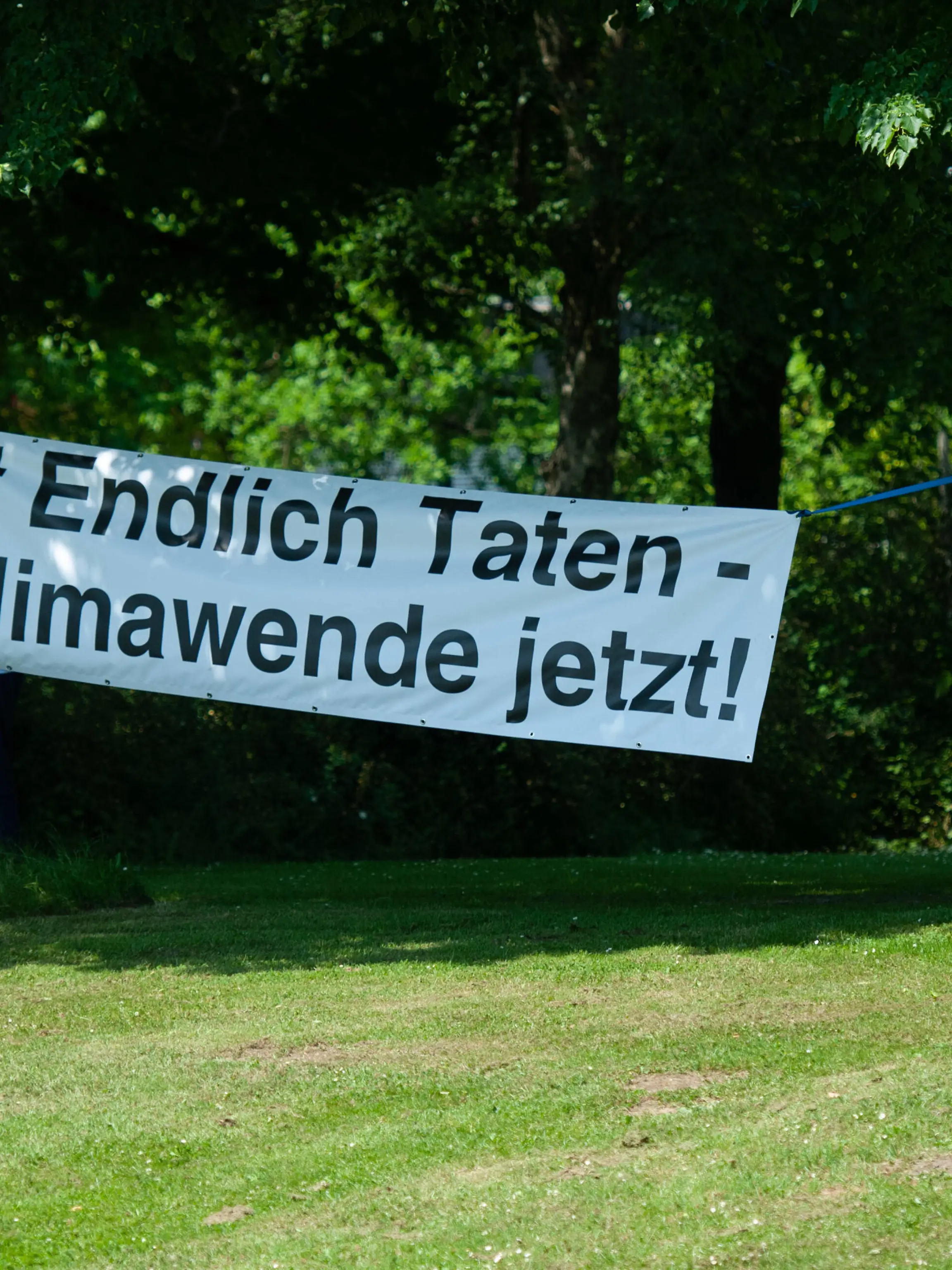 Kundgebung und Demonstration der Aktionsgruppe KLIMA Flensburg Transparent mit Aufschrift Endlich Taten Klimawende jetzt an Bäumen im Carlilse-Park befestigt. Aufnahme vom 18.06.2021, Flensburg, Bahnhofsumfeld, Carlisle-Park, Bahnhofsstraße *** Rally and demonstration of the action group KLIMA Flensburg banner with the inscription Endlich Taten Klimawende jetzt attached to trees in Carlilse Park photo taken 18 06 2021, Flensburg, Bahnhofsumfeld, Carlisle Park, Bahnhofsstraße 