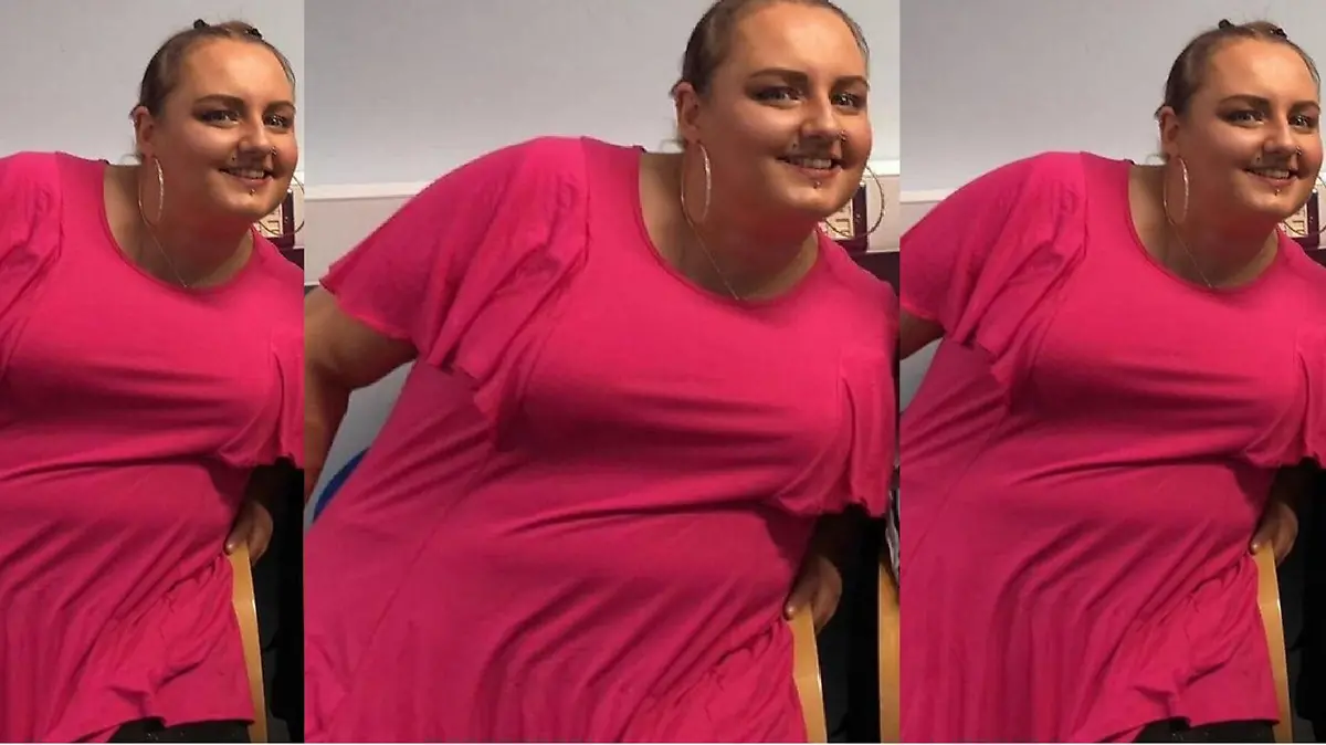 Eine Frau posiert in einem pinken Shirt und ist stark übergewichtig.