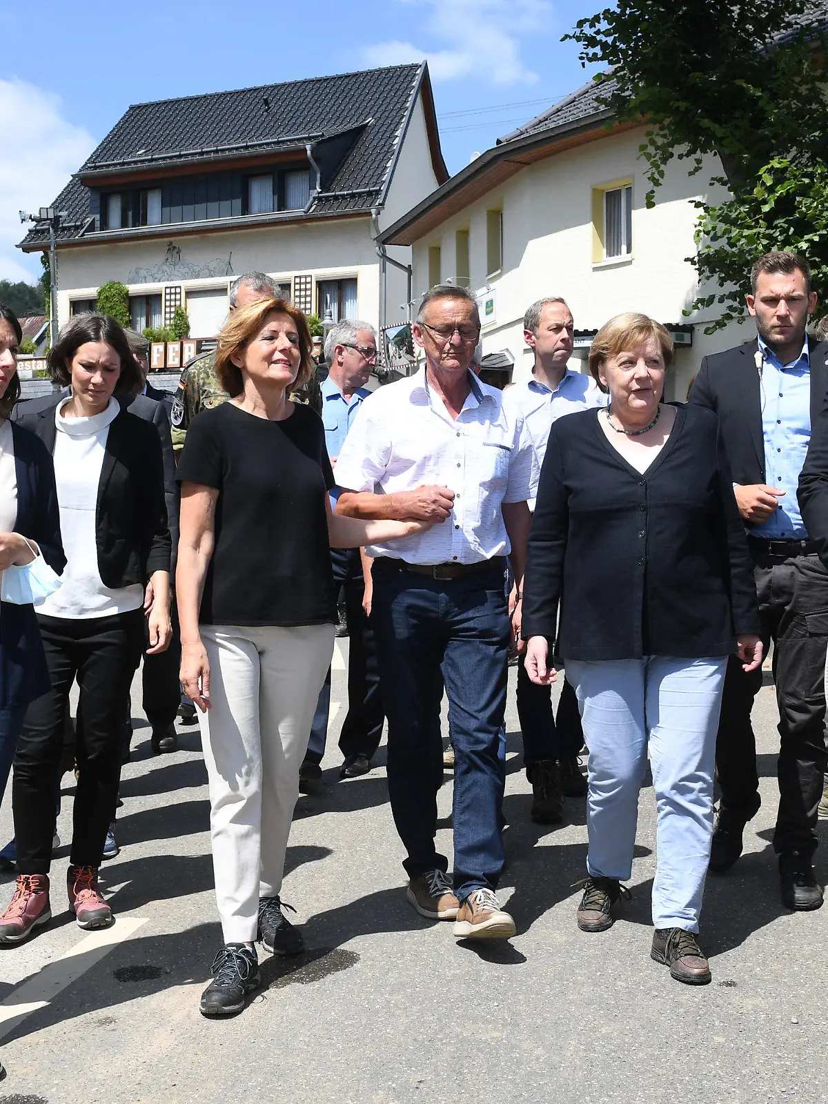 18.07.2021, Rheinland-Pfalz, Schuld: Bundeskanzlerin Angela Merkel (4.v.r) und Malu Dreyer (4.v.l, SPD), Ministerpräsidentin von Rheinland-Pfalz, gehen bei ihrem Besuch durch die Innenstadt von Schuld, um die Schäden von dem Hochwasser zu begutachten und mit Betroffenen zu sprechen. Foto: Christof Stache/POOL AFP/dpa +++ dpa-Bildfunk +++