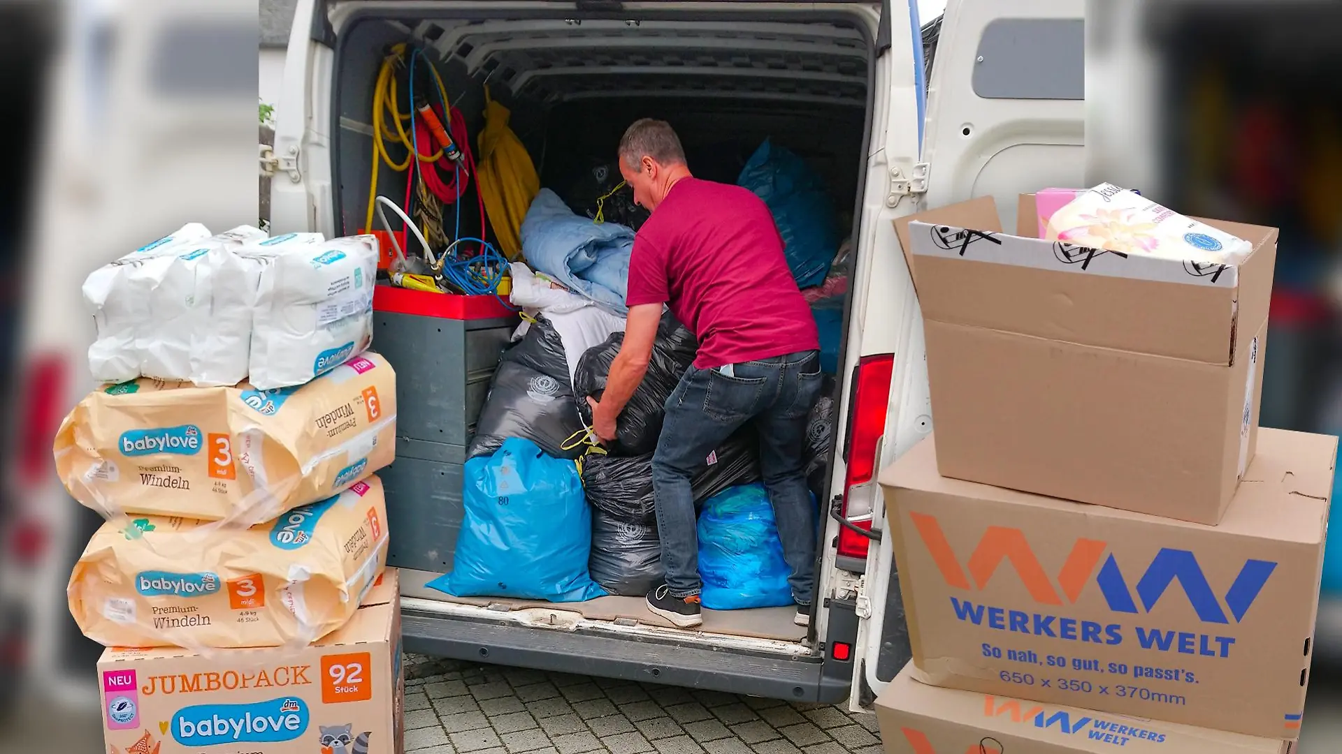 Freiwillige Helfer verladen die vielen Sachspenden in Transporter.